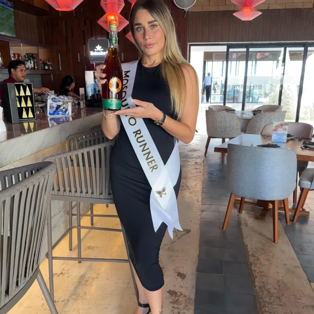 Edecán de Eleganz presentando una bebida en un restaurante